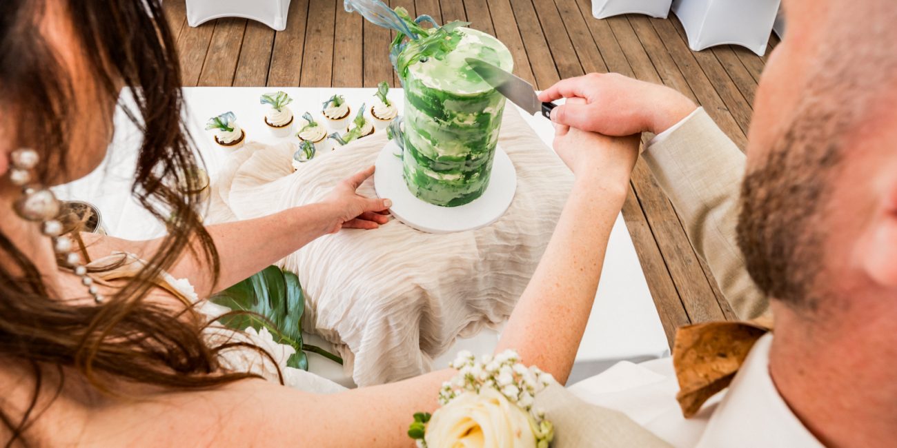 Brautpaar schneidet Hochzeitstorte an.